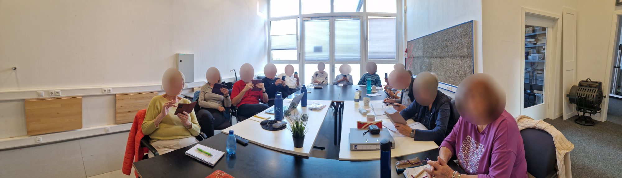 Kursgruppe des SeniorenNet Kiel mit Smartphones am Seminartisch